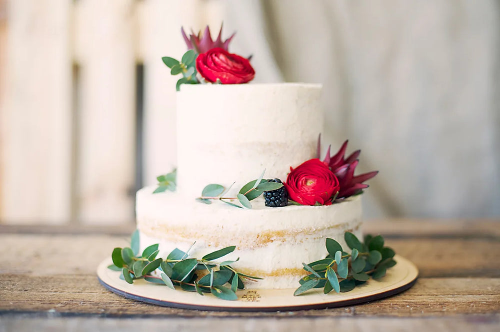 A Le 76 celebration cake finished with roses and eucalyptus