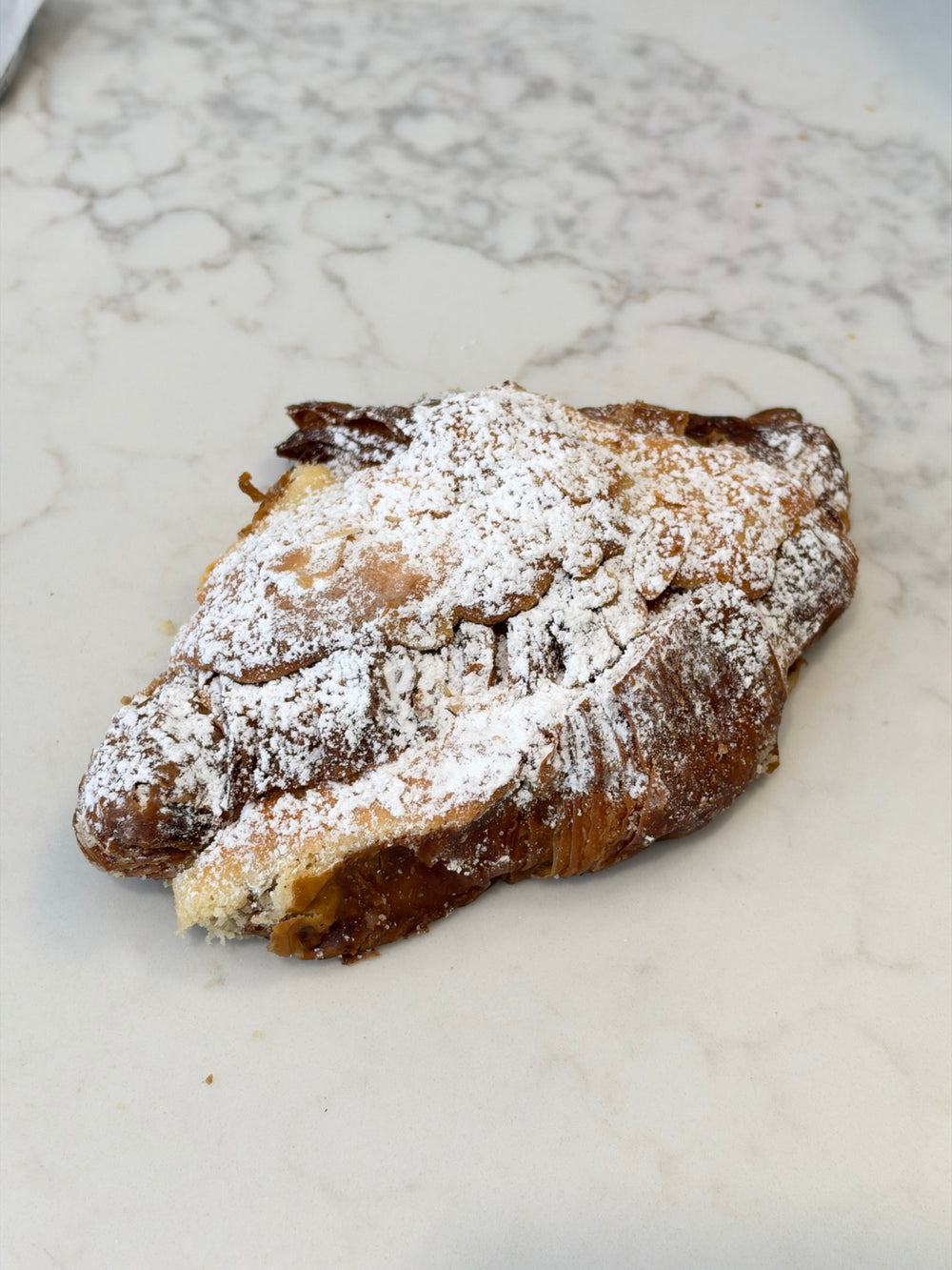 A Le 76 almond croissant, filled with almond cream and dusted with icing sugar