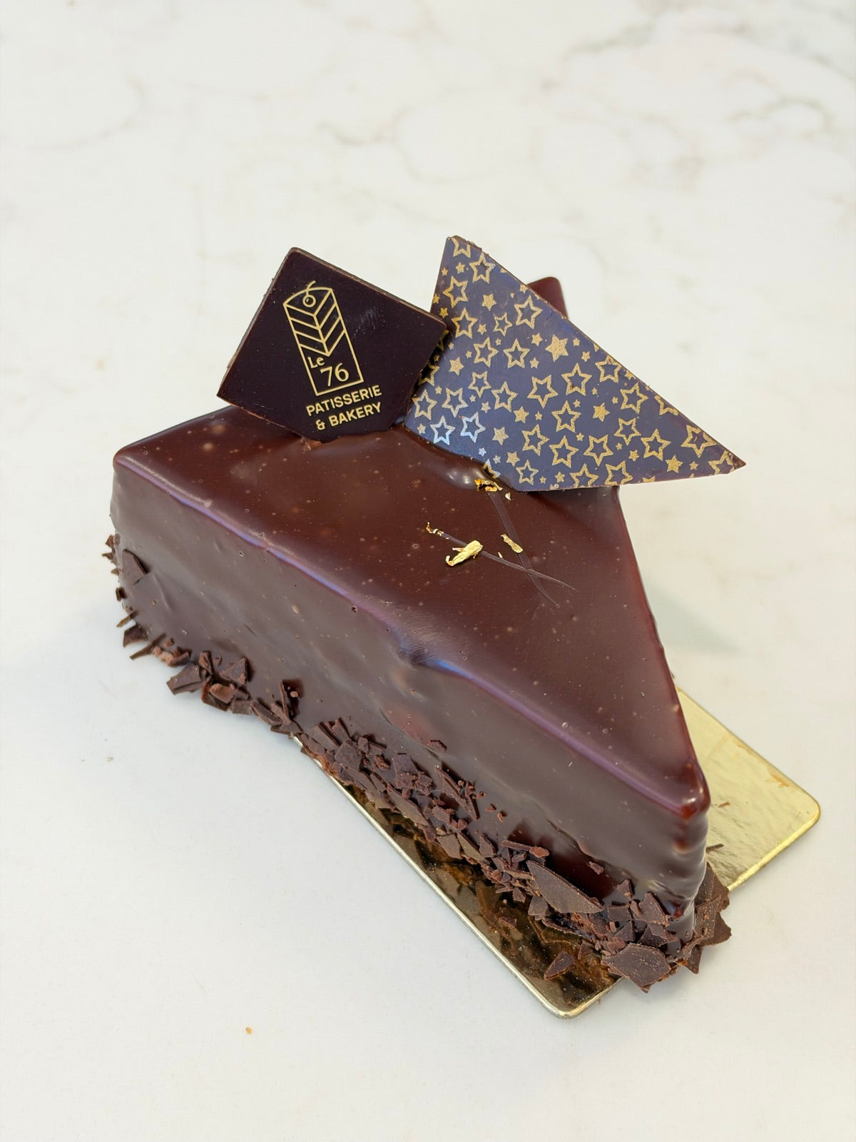 A slice of Le 76 gluten free chocolate mousse cake with a mirror glaze