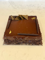 A whole Le 76 gluten free chocolate mousse cake, glazed and finished with chocolate