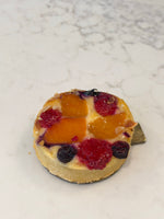 An individual Le 76 frangipane tart topped with fruit and berries