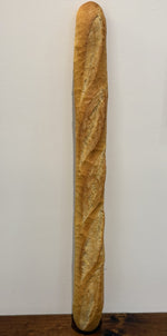 A Le 76 baguette, slashed and baked to a deep gold