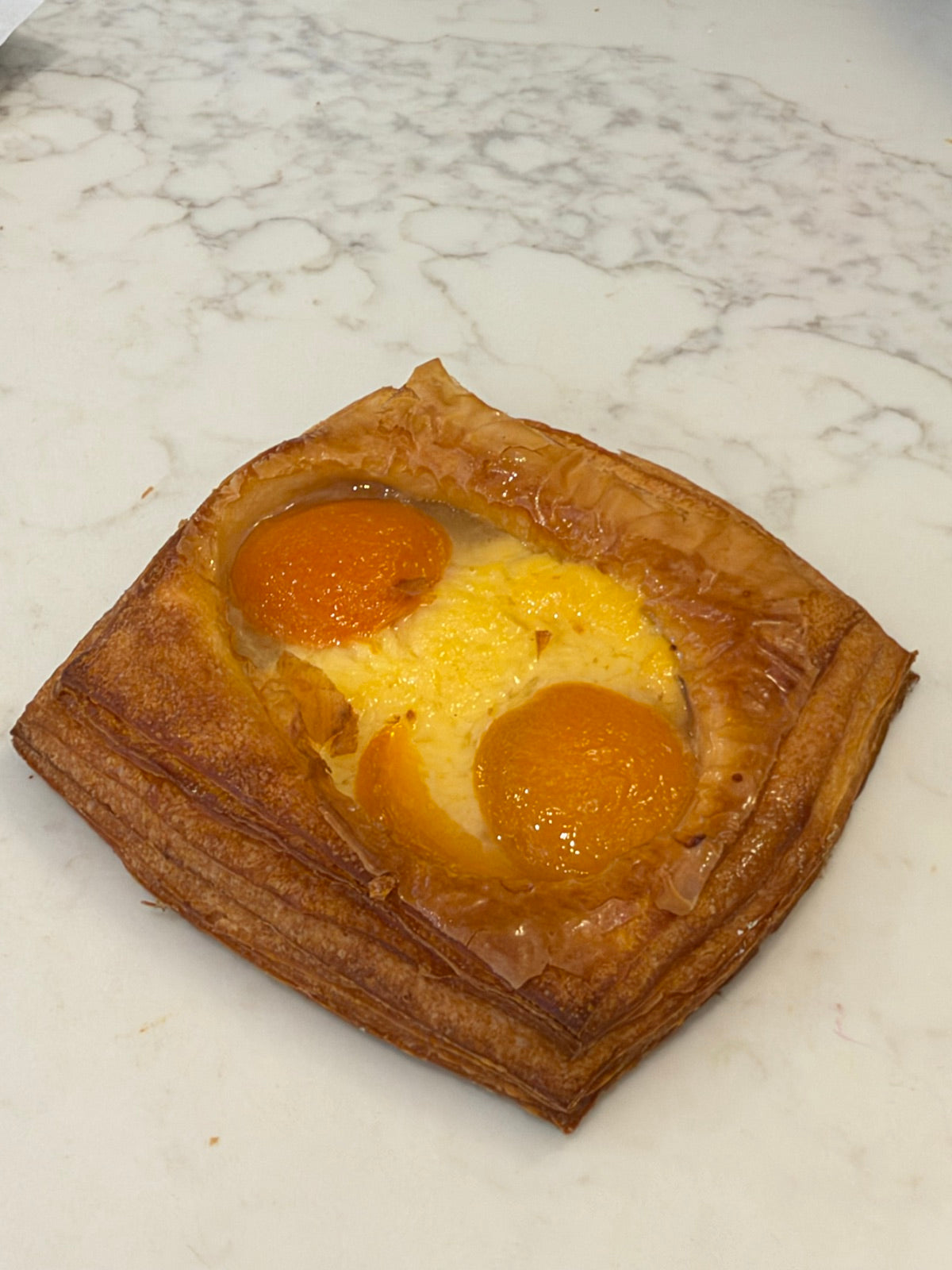 A Le 76 fruit danish with apricot halves set in creme patissiere
