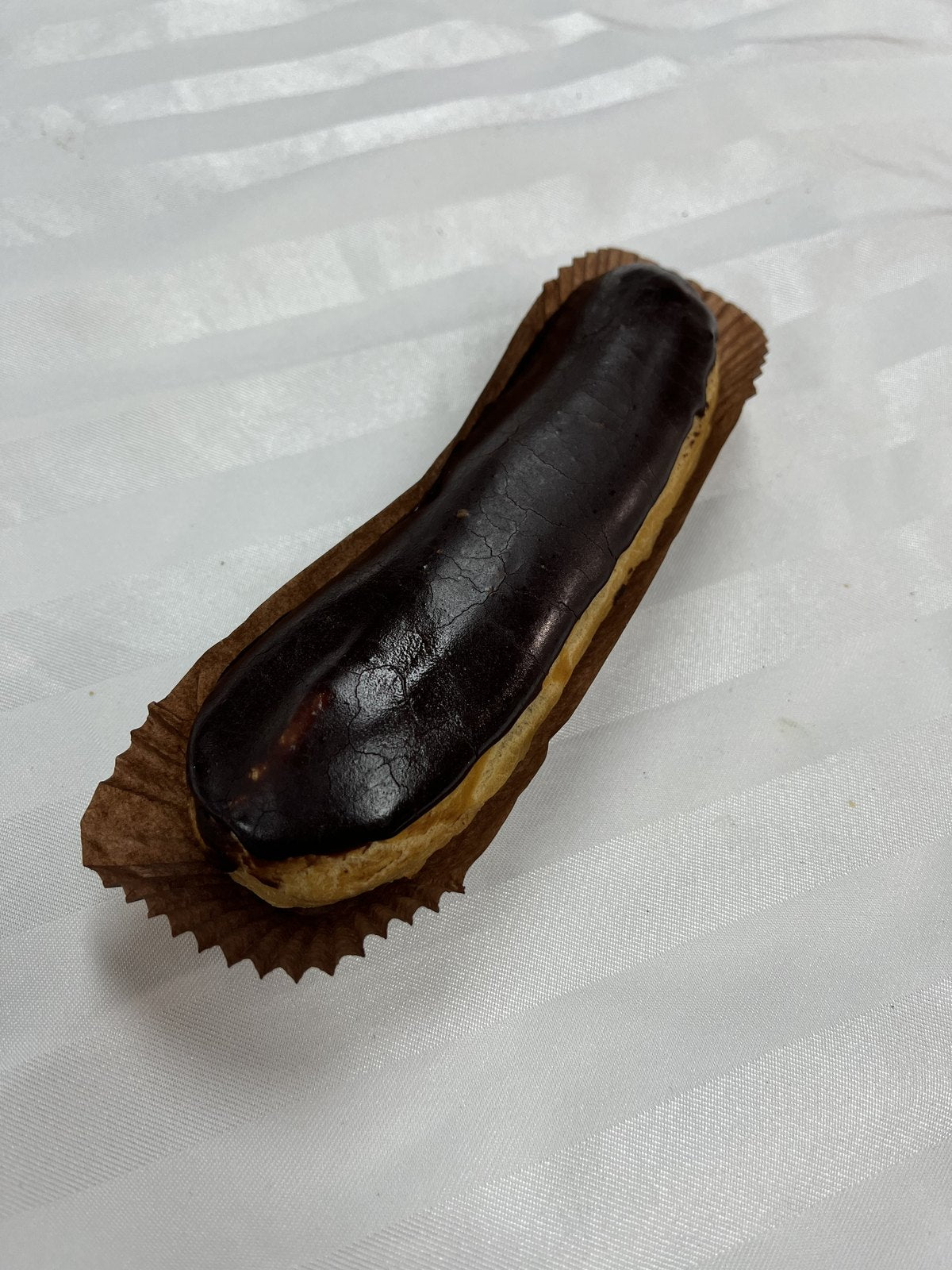 A Le 76 chocolate éclair, choux pastry glazed in dark chocolate