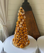 A croque en bouche made by Le 76, a tower of caramel-glazed choux buns finished with spun sugar and sugared almonds