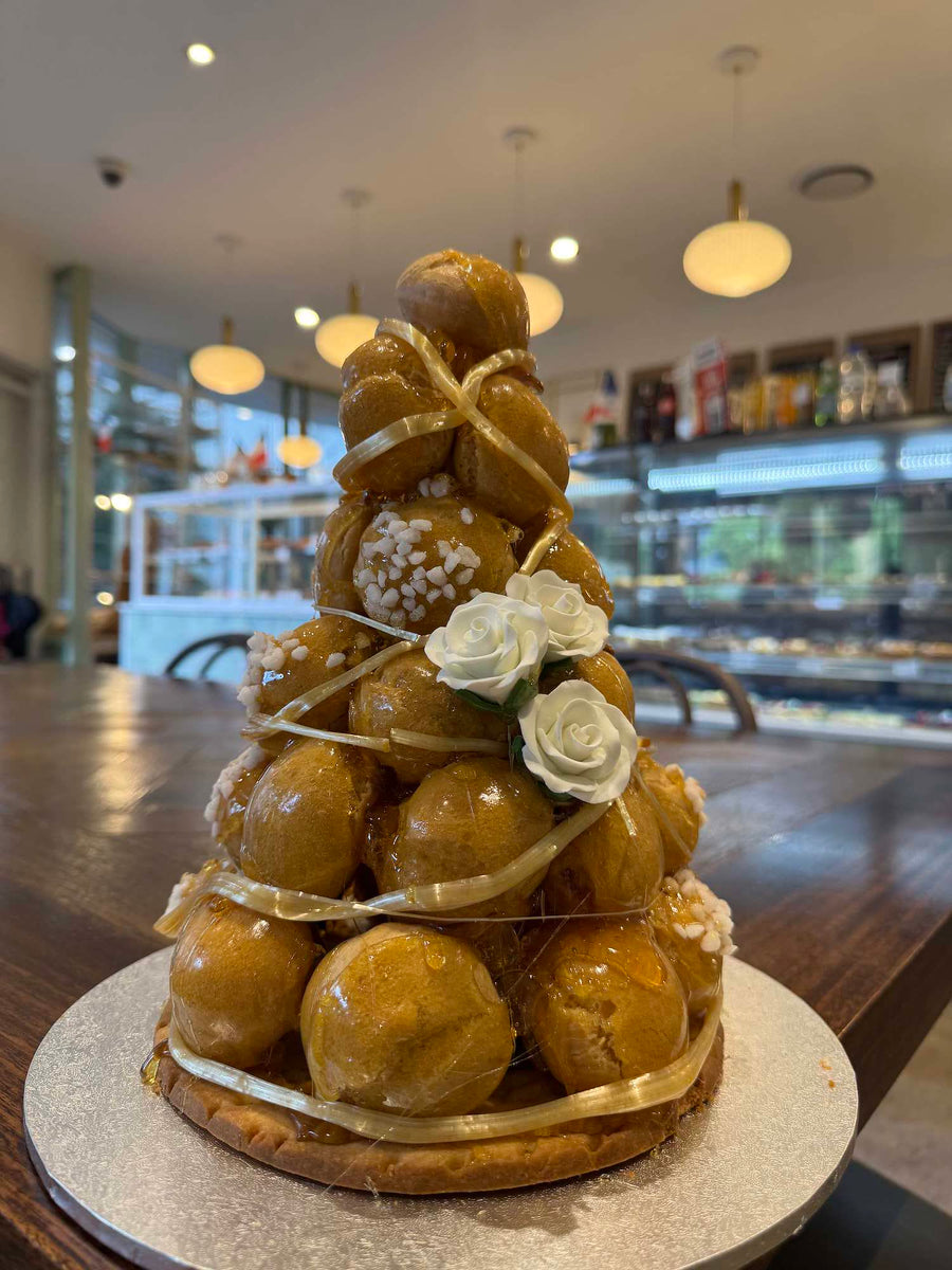 A Le 76 croque en bouche, a tower of caramel-glazed choux buns dressed with white sugar flowers