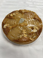 A whole Le 76 pear and almond tart, pear halves fanned across the top with flaked almonds