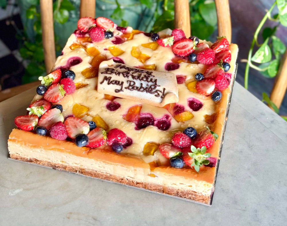A Le 76 cake finished with fruit and a piped message plaque