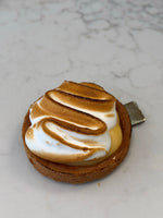 An individual Le 76 lemon meringue tart with torched meringue