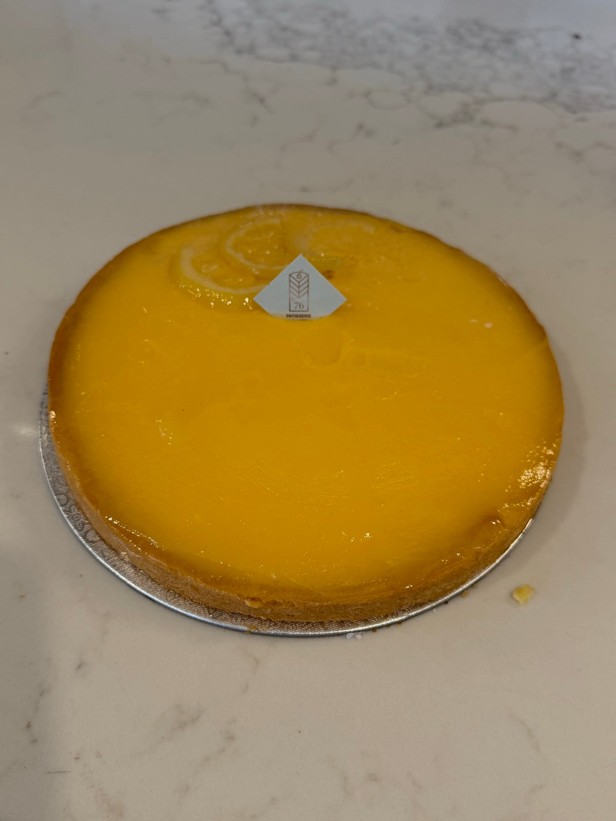 A whole Le 76 lemon tart, the curd set to a clean glossy surface