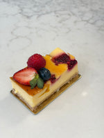 A slice of Le 76 baked cheesecake with mango and fresh berries