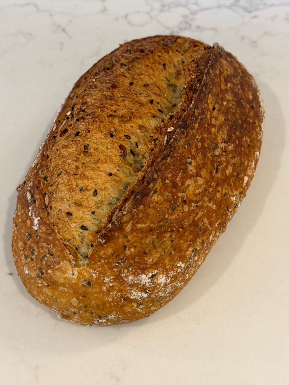 A Le 76 multigrain sourdough loaf, crusted with seeds and grains