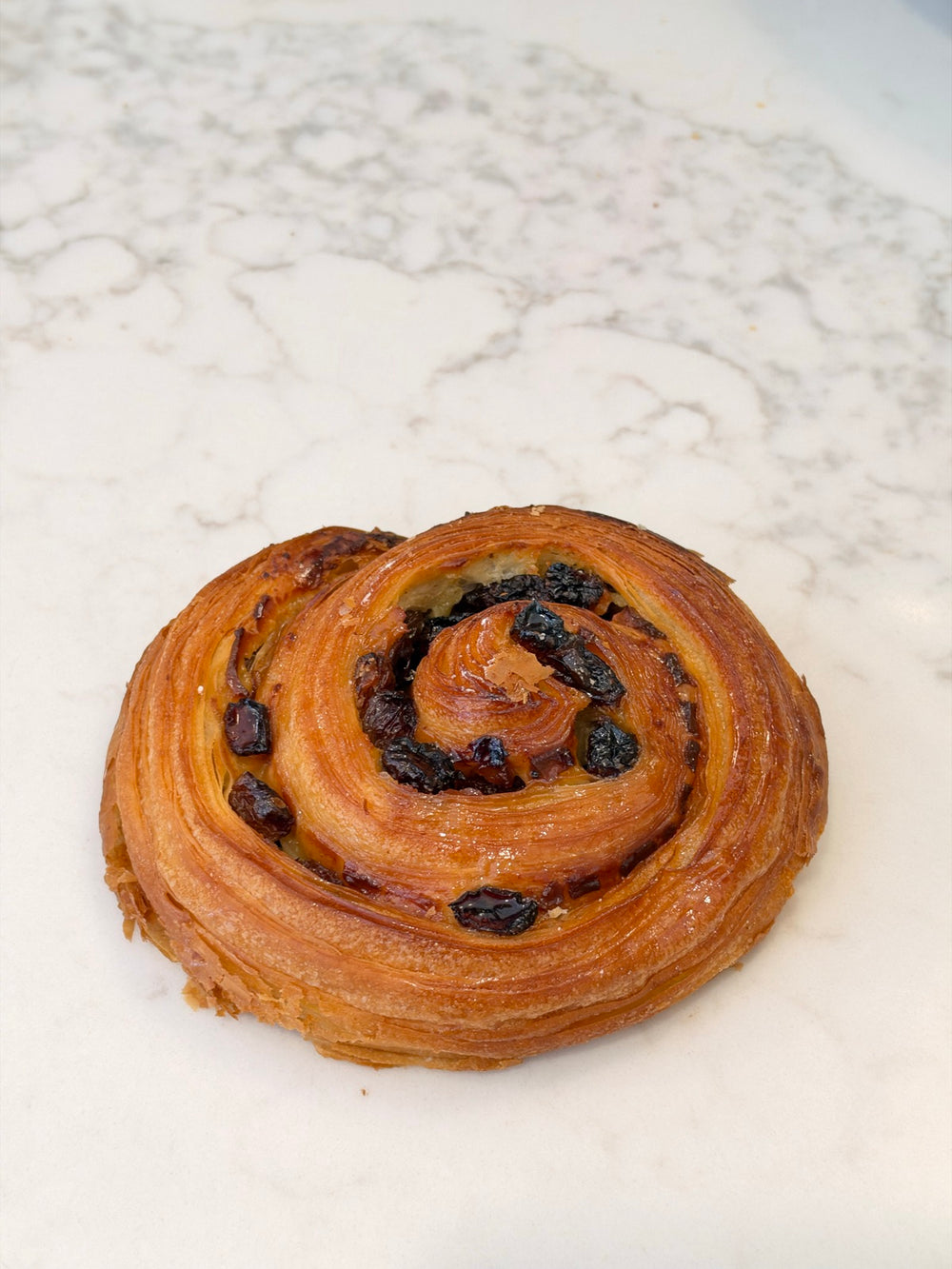 A Le 76 pain au raisins, the snail, rolled with creme patissiere and raisins