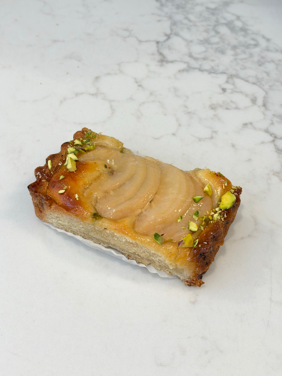 A Le 76 pear and pistachio slice, topped with poached pear and chopped pistachio