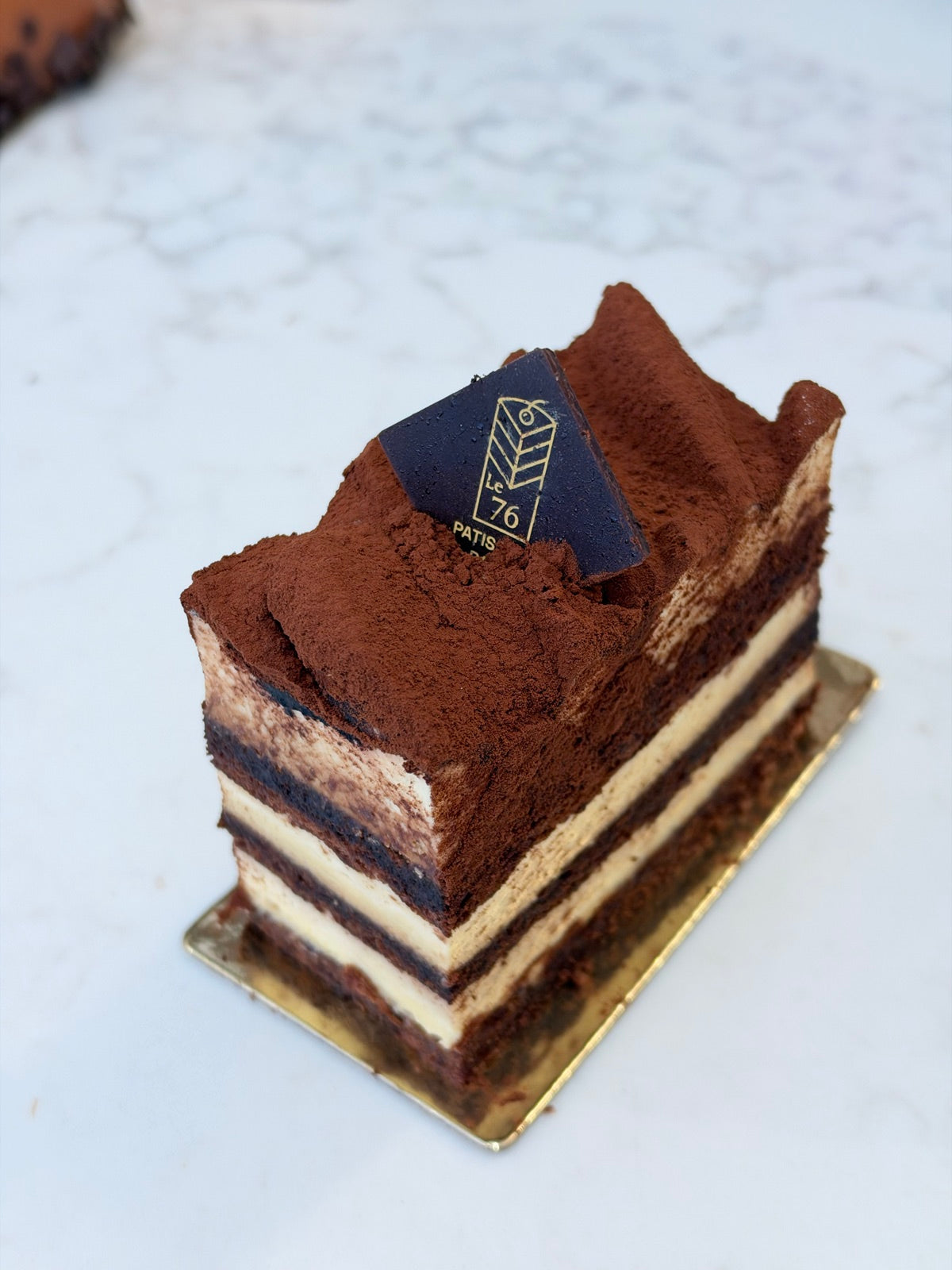 A slice of Le 76 tiramisu, layered and dusted with cocoa